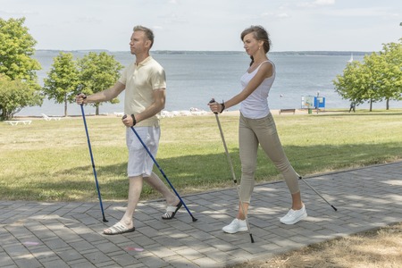 Youngfamily in love couple hiking in the nature nordic walkingの写真素材