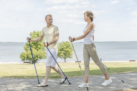 Young couple hiking in the nature nordic walking near the lakeの写真素材