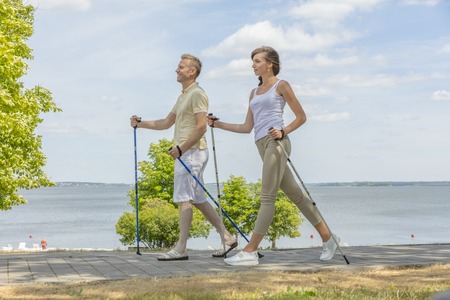 husband and wife hiking in the nature nordic walkingの写真素材