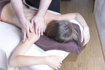Spa woman. Female enjoying relaxing shoulder massage in cosmetology spa centre. Body care, skin care, wellness, wellbeing, beauty treatment concept.の写真素材