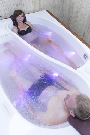 Young happy couple enjoying bath in the bathtub - Couple of lovers on a date in spa centerの写真素材