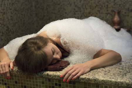 Young woman in hammam or turkish bath soap foam.の写真素材