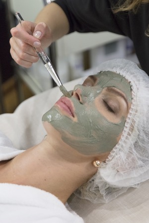 Young beautiful girl receiving lifting facial mask in spa beauty salon - indoorsの写真素材
