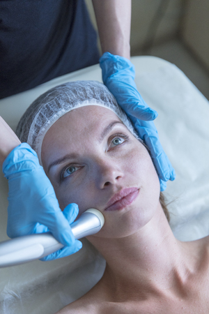 Beautiful woman in professional beauty salon during photo rejuvenation procedureの写真素材
