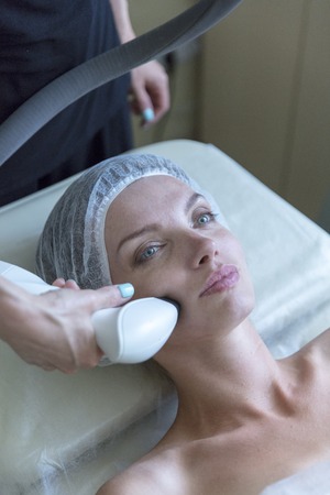 Beautiful woman in professional beauty salon during radio lifting procedureの写真素材