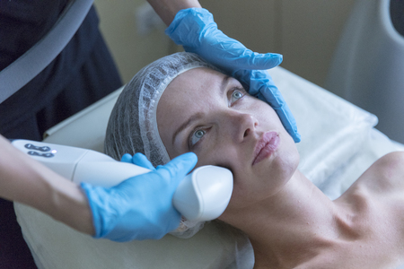Beautiful woman in professional beauty salon during photo rejuvenation procedureの写真素材