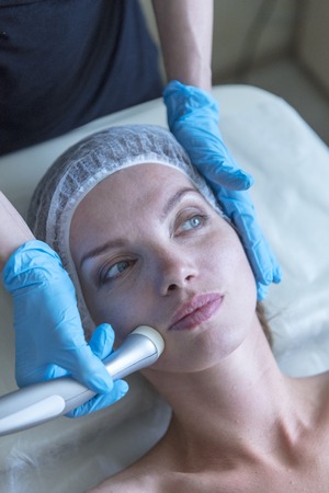 Beautiful woman in professional beauty salon during photo rejuvenation procedureの写真素材