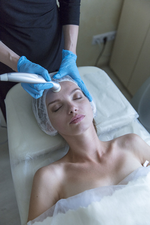Beautiful woman in professional beauty salon during photo rejuvenation procedureの写真素材