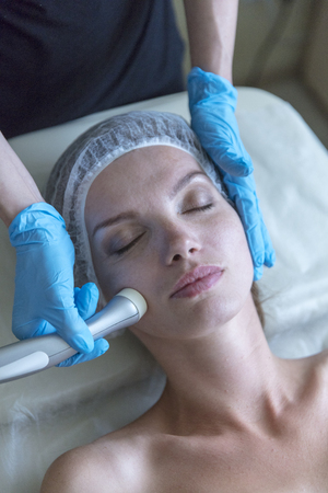 Beautiful woman in professional beauty salon during photo rejuvenation procedureの写真素材