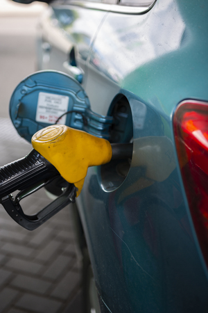 the fuel tank of the vehicle with diesel or gasoline at a filling stationの写真素材