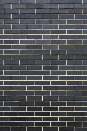 modern stone black bricks with white seams wall pattern texture background verticalの写真素材