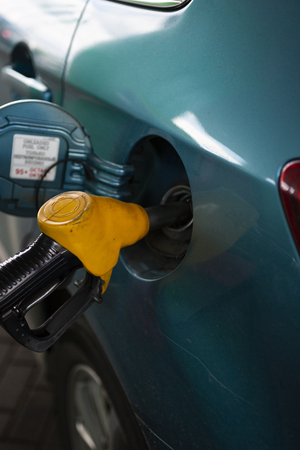 refueling the fuel tank of the vehicle with diesel or gasoline at a filling stationの写真素材
