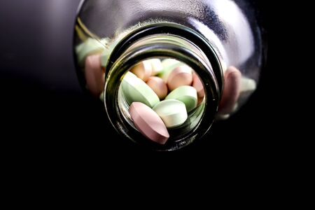 Pills in a bottle black background. Drugs, painkillers, colds and other medicineの写真素材