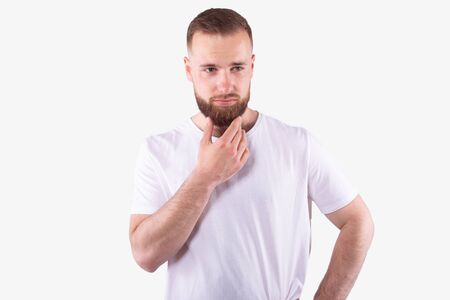 Pensive man holding hand on chin, looks to side. Making a decision conceptの写真素材