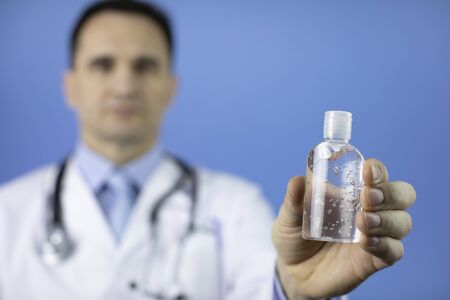 Doctor in lab coat with sanitizer in hand to prevent spread of coronavirusの写真素材