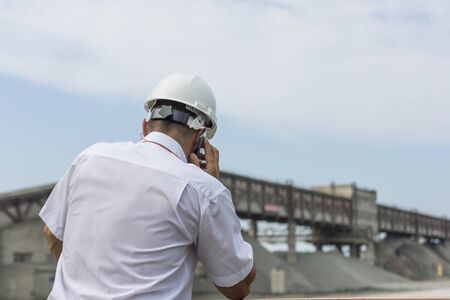 Mining engineer in white shirt and helmet supervises work of granite workshopの写真素材