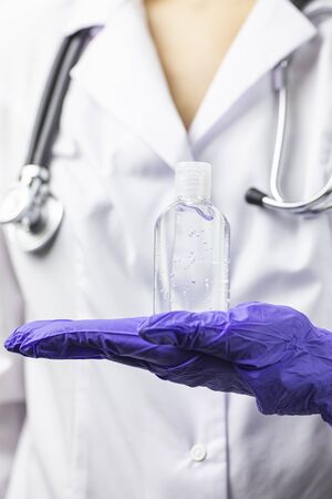 Close up sanitizer dispenser in doctors hand. Protection, recommendationの写真素材