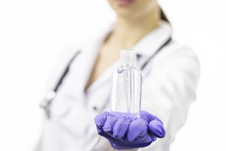 Close up doctor holding alcohol gel dispenser. Focus on antiseptic. Hygieneの写真素材