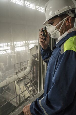 Mining engineer in white helmet respirator supervises work of granite workshopの写真素材