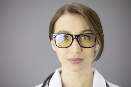 Sexy female doctor in glasses with yellow lenses is looking at the cameraの写真素材