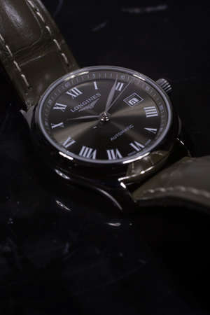 Saint-Imier, Switzerland 31.03.2020 - Closeup image of Longines watch lying on a marble table stainless steel case black clock face dial leather strap selective focus swiss quartz mechanical watch swiss made manufactureのeditorial素材