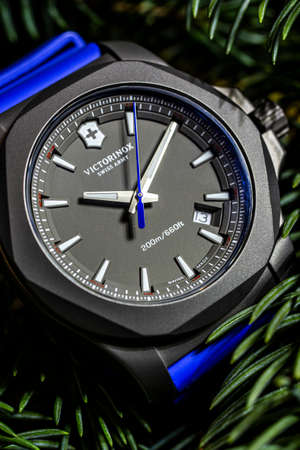 Ibach, Switzerland 31.03.2020 - The close up of Victorinox man watch carbon case rubber strap grey clock face dial swiss quartz mechanical watch swiss made manufacture lying on spruce branchesのeditorial素材
