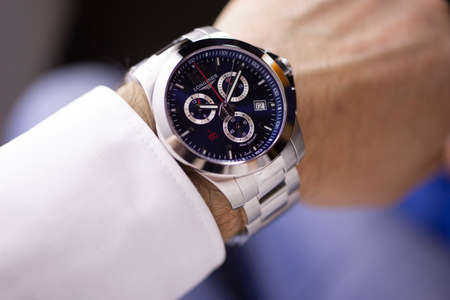 Saint-Imier, Switzerland 31.03.2020 - Closeup fashion image of Longines watch on wrist of man Longines man watch stainless steel case black clock face dial stainless steel bracelet swiss quartz watch swiss made manufactureのeditorial素材
