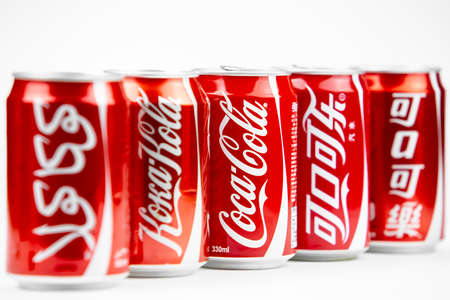 Atlanta, Georgia, USA April 4, 2020: five cans of Coca-Cola with a logo in different languages:...