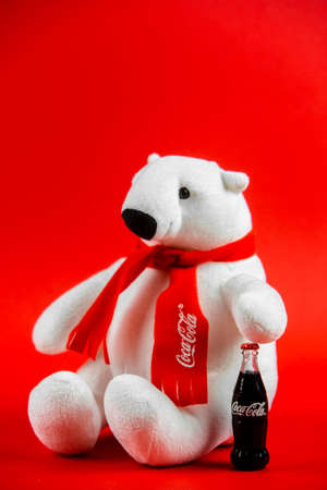 Atlanta, Georgia, USA April 1, 2020: souvenir polar bear Coca-Cola sitting isolated on red background and Coca Cola toy contour bottleのeditorial素材