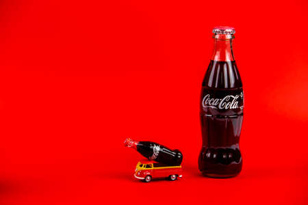 Atlanta, Georgia, USA April 1, 2020: Vintage die cast toy Transporter T1 with Coca-Cola ad 1960âs carrying contour Coca Cola toy bottle and Coca Cola contour bottle isolated on red backgroundのeditorial素材