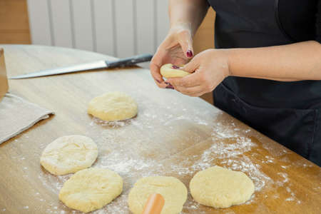 close up of young housewife woman hands kneading the dough while making homemade pastry in kitchen...