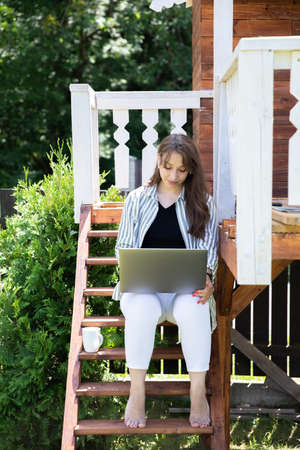 Young businesswoman in earphones watching distance webinar, female freelancer working on laptop, attractive woman study online. Home office, modern lifestyle concept, digital, remote work, e-learningの写真素材
