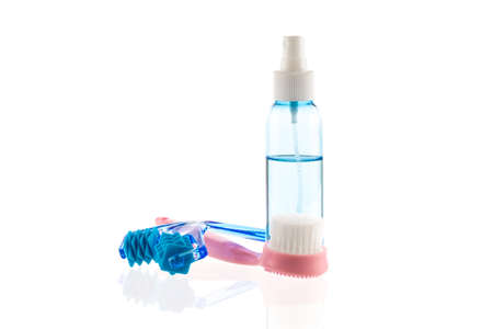 Skin care set isolated on white background. Transparent bottle with liquid facial moisturizing spray and cleansing brush, derma roller kit for face massage, skincare tools for daily deep cleansingの写真素材