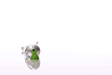 Squeezed green tube of acrylic paint isolated on white background. Smear of oil paint color on...