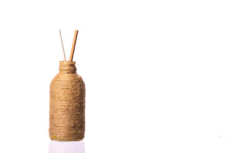 Two drinking straws of recycled paper in glass bottle wrapped with natural jute hemp rope. eco friendly modern ecological biomaterials. Zero waste concept.の写真素材