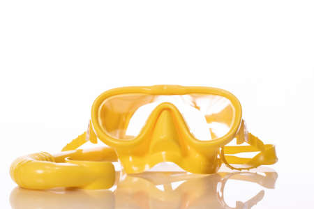 yellow silicone set for diving, mask and snorkel reflected in glass table surface, equipment for...
