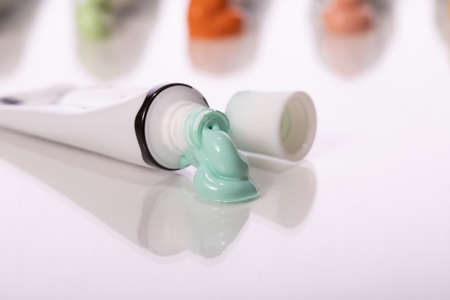 volumetric smear, large drop of light green glossy paint squeezed out of tube reflected in glass...