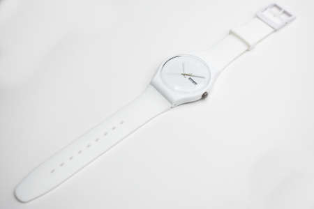 London, GB 07.10.2020 - Swatch cheapest swiss made quartz watch isolated on white background. white plastic case, day and date Tuesday 23. Swatch Group watch productionのeditorial素材