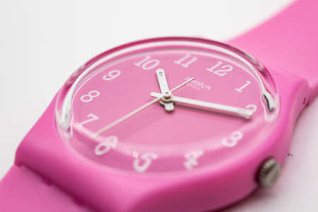 Paris, France 07.10.2020 - Swatch logo on pink wristwatch dial childrens cheapest fashion swiss made quartz watch isolated on white background. colored plastic case, youth hipster style watchのeditorial素材