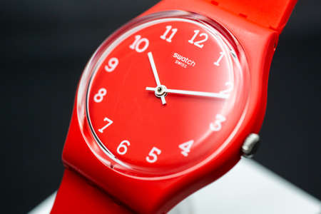 London, GB 07.10.2020 - Swatch swiss made quartz watch on brand showcase stand. red plastic case,...