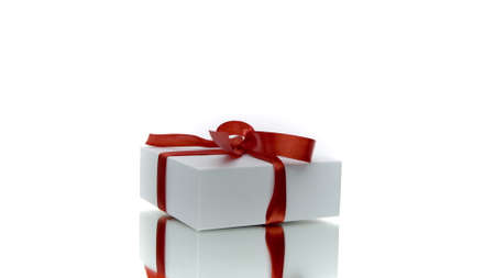 Beautiful white gift box with red bow rotating isolated on white background. Present in motion, surprise, valentines womens day greeting, holiday congratulations, store promotion concept. Close upの写真素材