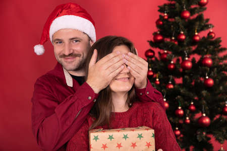 Romantic surprise for Christmas, pretty woman receives gift from her boyfriend, man closes girls...