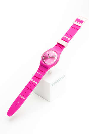 Rome, Italy 07.10.2020 - Swatch on pink wristwatch dial. childrens swiss made quartz watch isolated on white backdrop. date time, hearts design. Love round clock. Romance all day longのeditorial素材