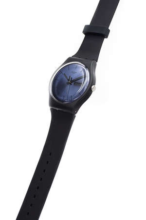 Geneve, Switzerland 07.10.2020 - Swatch cheapest trendy swiss made plastic watch on stand, simple black design, blue dial, Value Price concept. Swatch Group watch productionのeditorial素材