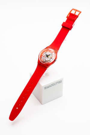 Paris, France 07.10.2020 - Swatch trendy swiss made quartz red color watch on stand. open electronic mechanism in transparent caseのeditorial素材
