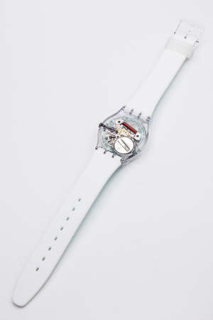 Paris, France 07.10.2020 - Swatch childrens cheapest trendy swiss made quartz watch back case battery compartment. open electronic mechanism in transparent caseのeditorial素材