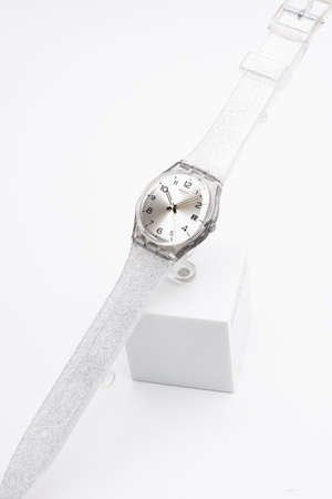 Rome, Italy 07.10.2020 - Swatch fashion swiss made quartz watch close up on stand. transparent plastic case and pearlescent strap, stylish trendy womens accessory. young businesswoman fashion detail.のeditorial素材