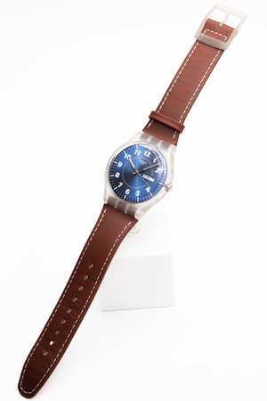 Rome, Italy 07.10.2020 - Swatch classic design swiss made mechanical watch isolated on white close up. transparent plastic case, date Friday 1, brown leather strap. plastic instead of metal conceptのeditorial素材