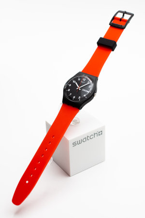 Rome, Italy 07.10.2020 - Swatch fashion swiss made quartz watch isolated on brand stand. black plastic case, red strap. Swatch Group watch productionのeditorial素材