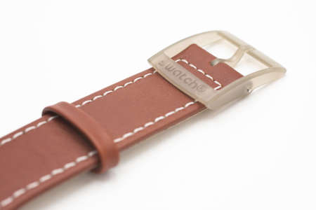Rome, Italy 07.10.2020 - Swatch on brown watch wrist strap of swiss made quartz watch isolated on white background close up. Swatch Group watch productionのeditorial素材